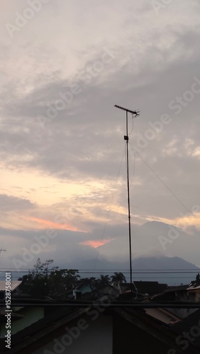 scenery of the gray sky with the roofs of houses and antenna