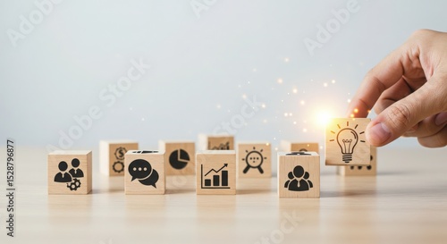 Hand arranging wooden blocks with icons representing business growth and planning strategy 