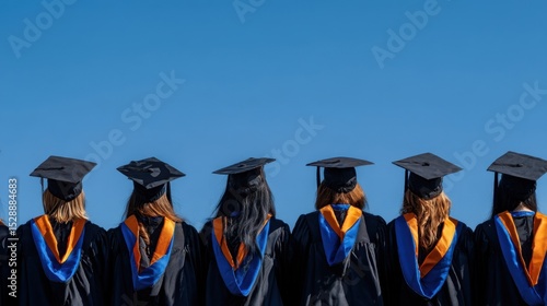 The group of graduates celebrating their achievements under a clear blue sky.