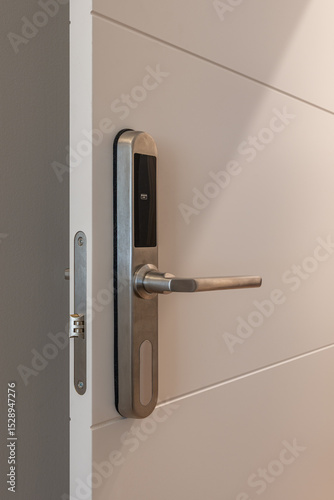 Close up of modern electronic door lock with stainless steel handle on white door in interior setting