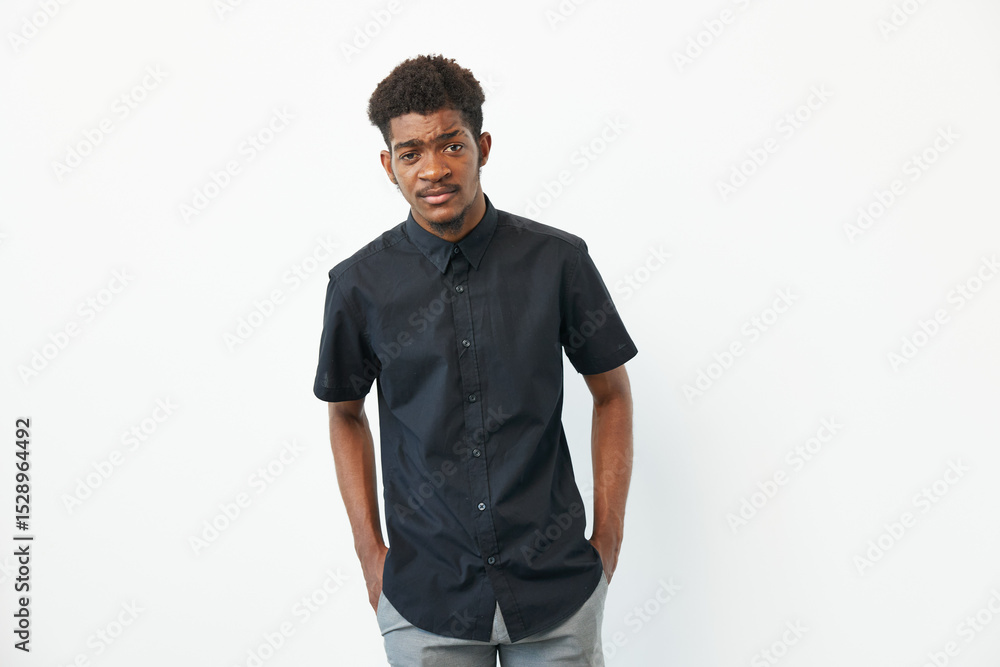 A stylish young African American man in a black shirt stands confidently against a white background, showcasing modern fashion and an approachable demeanor. A stylish young African American man in a black shirt stands confidently against a white background, showcasing modern fashion and an approachable demeanor.