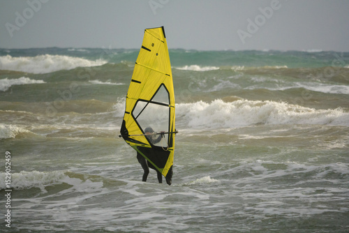 Tableau sur toile Water Sport Activity - Windsurfer Riding a Wave in Rough Sea on a Windy Day