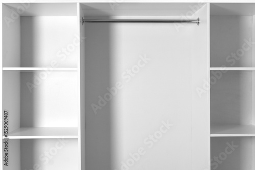 Minimalist empty white wardrobe with shelves and a metal clothes rail. Clean, modern and ready for organization.