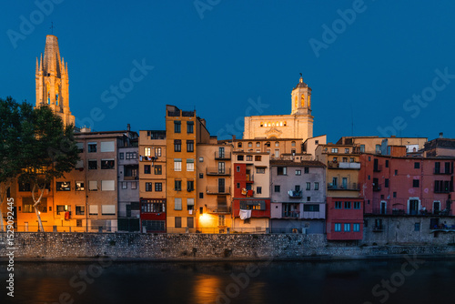 Malerische Ansicht der bunten Häuser von Girona entlang des Onyar Flusses bei Nacht