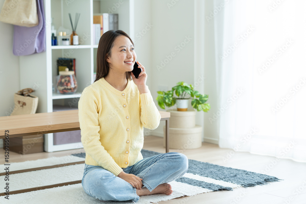 リビングで電話する若い女性 リビングで電話する若い女性