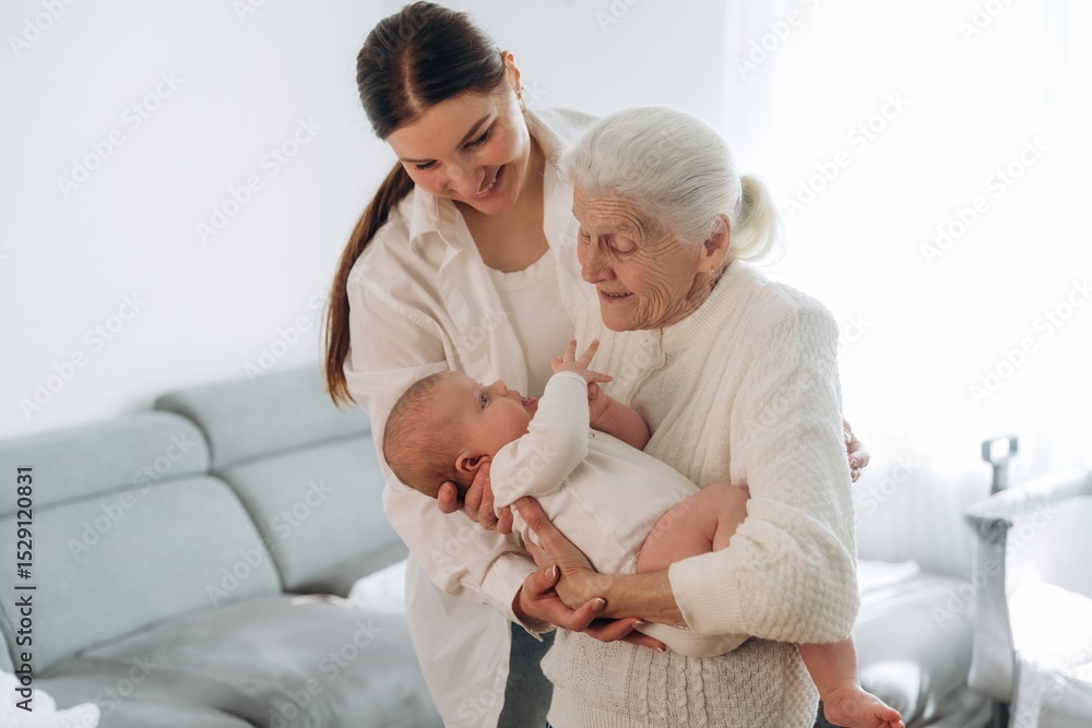 Obraz premium Cheerful facial expression. Mother, grandmother and little baby child on hands indoors