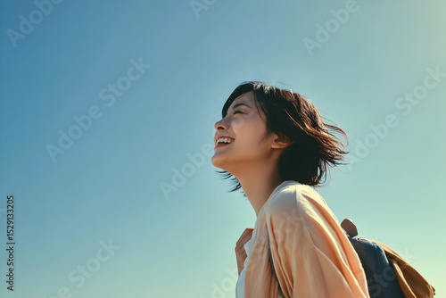 Carefree Woman Outdoors Smiling Brightly Against Clear Sky Capturing Freedom and Optimism