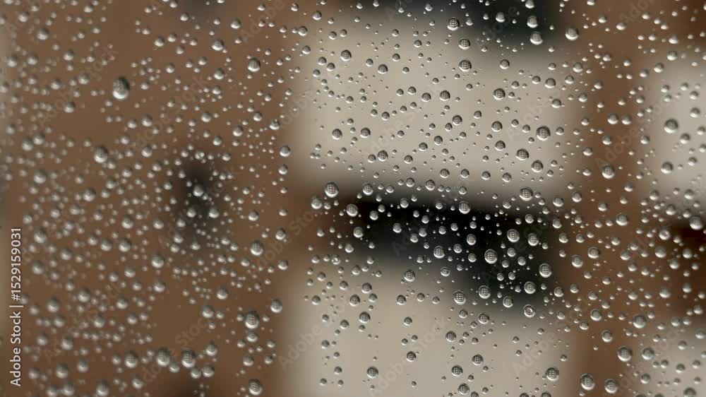 Raindrops on window glass with reflection of city buildings in water drops close up Raindrops on window glass with reflection of city buildings in water drops close up