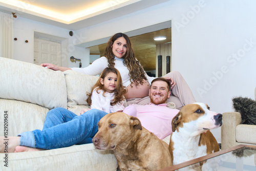 Photography Happy family relaxing on sofa with dogs in living room