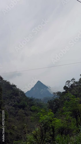 view of towering cone-shaped mountains with settlements in the mountain valleys.