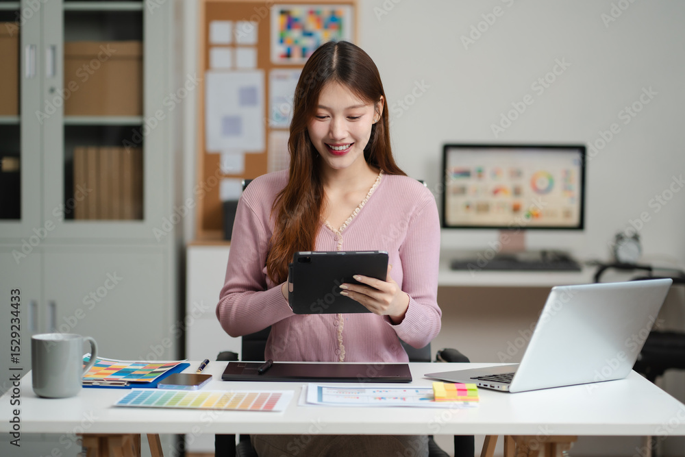 Female coder or developer working using a Tablet and computer display in problem solving at workplace. Female coder or developer working using a Tablet and computer display in problem solving at workplace.