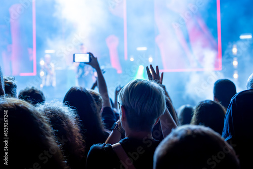 Photos The audience records videos and takes photos with their smartphones during the concert of the musical band that performs on stage