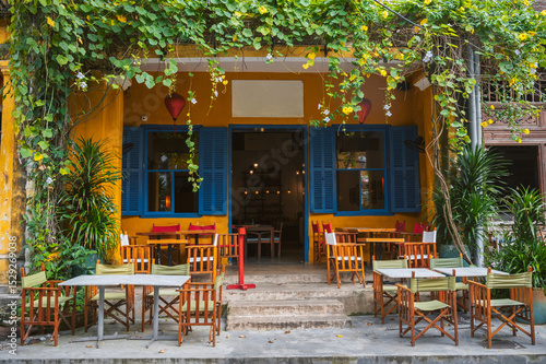 Cozy and beautiful restaurant on Hoi An street with empty tables.