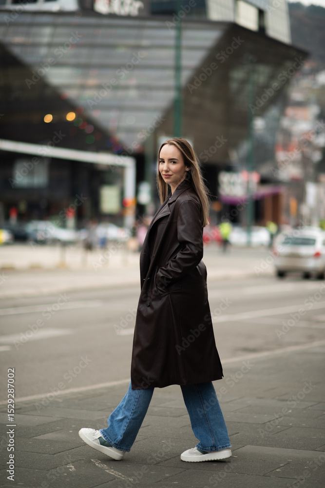 Stylish woman posing in leather coat on city street Stylish woman posing in leather coat on city street
