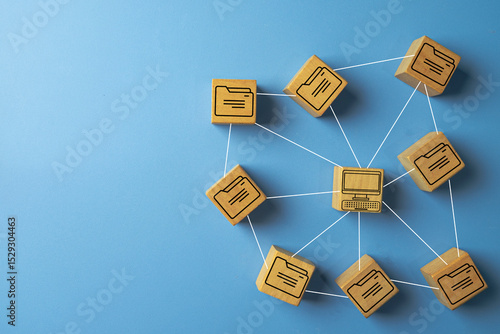 A central computer on a wooden block connected to a network of file folder icons. Concept for a Document Management System (DMS), file sharing,file storage, data management,cloud storage.