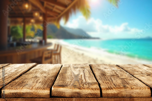 Empty wooden table with open space for product placement or branding. In the background blurred summer scene with sandy coastline and beach cafe and the blue sea under sunny sky.