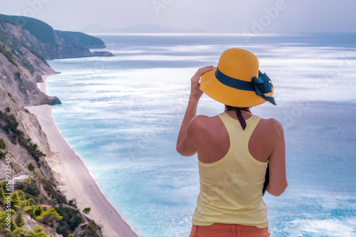 Young woman relaxing on the beach near the sea during a summer season