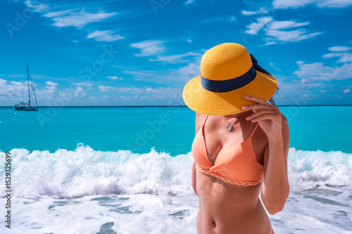 Young woman relaxing on the beach near the sea during a summer season