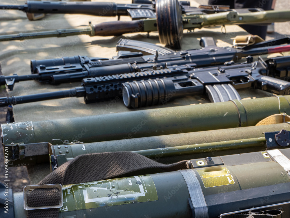 A bunch of guns are lined up on a table A bunch of guns are lined up on a table