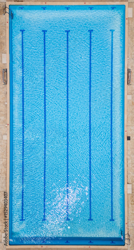 Fotografie Top-down view of an empty swimming pool with lane dividers and clear blue water