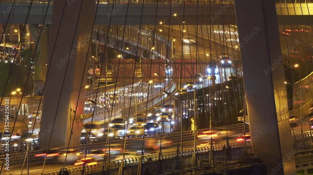 Night traffic streaming across viaduct road near urban city at night with light streaks from moving vehicles Night traffic streaming across viaduct road near urban city at night with light streaks from moving vehicles
