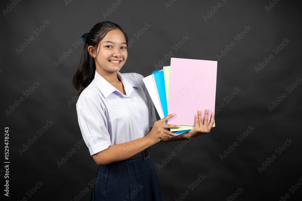 Obraz premium An Asian high school girl in her school uniform stands in a studio background, thinking about how her daily efforts will help her get into a top university next year.