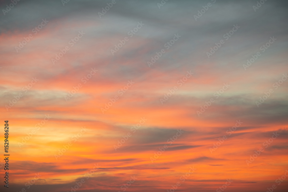Fototapeta premium Sky,Beautiful sunset view, luxury soft gradient orange gold clouds and sunlight on the blue dramatic sky perfect for the background, morning, evening,Twilight, climate change,horizontal sunset photo