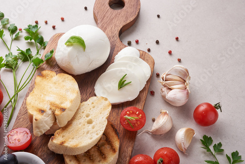 Fresh bruschetta with tomatoes, mozzarella cheese and basil on a cutting board. Traditional italian appetizer or snack, antipasto. Top view. Flat lay. Ciabatta with cherry tomato.