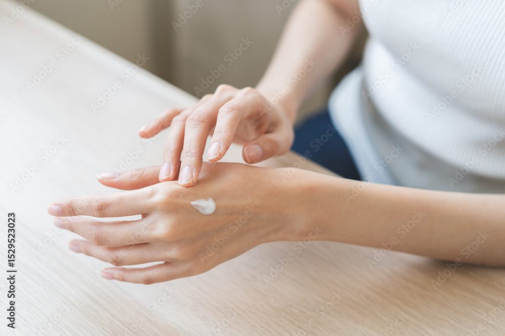 Naklejka premium Healthy skin care, beauty asian young woman hand applying moisturizer, putting cream treatment on back hand after shower bath at home, makeup routine in the morning, treatment skin care body concept.