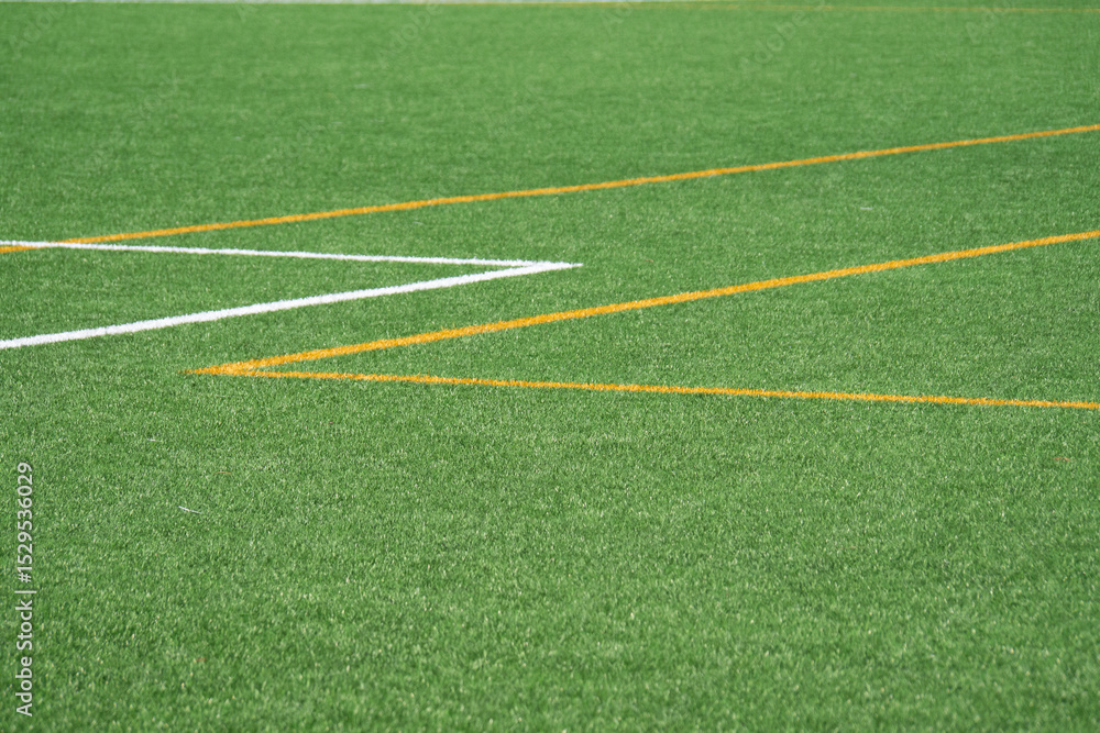 Obraz premium Bright green turf with sharp lines on a sunny sports field