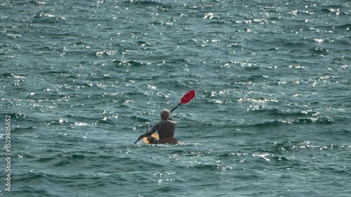 Man Kayaking Ocean - A man paddles a kayak on choppy water, enjoying a day of water sports.
