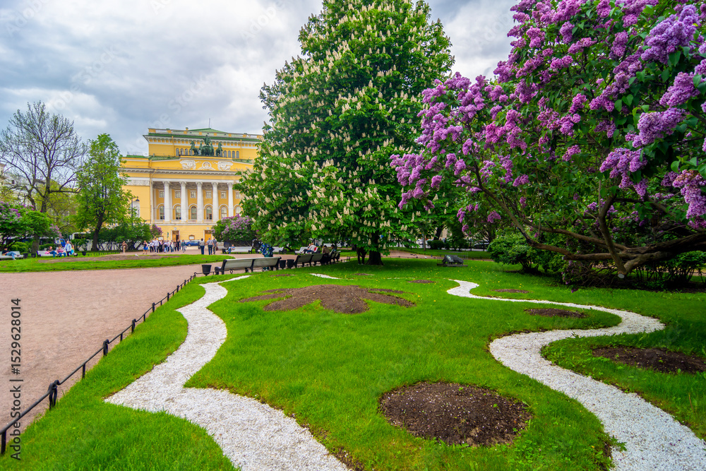 Fototapeta premium St. Petersburg, Russia - 29 may 2025: Spring Petersburg. Blooming lilacs against the backdrop of the Alexandrinsky Theater