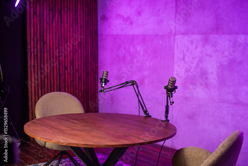 Podcast studio setup with two microphones and cozy chairs designed for engaging broadcasts and discussions
