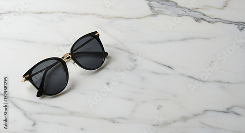 Kacamata hitam elegan di atas permukaan marmer putih melambangkan gaya hidup modern dan estetika fashion minimalis yang mewah