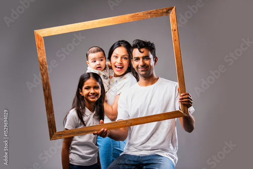Photography Looking through photo frame Indian family smiles joyfully sitting together again