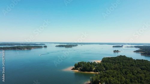 Wallpaper Mural Aerial drone footage flying over a scenic lake with small islands surrounded by green trees and clear blue water. Captures the peaceful beauty of nature from above. Torontodigital.ca