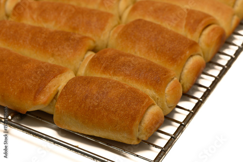 фотографія Warm homemade Parker House rolls cooling on a wire rack at the kitchen table