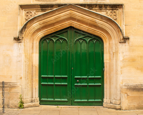 antique green door of building (church, cathedral) with decorative moulding on wall in oxford