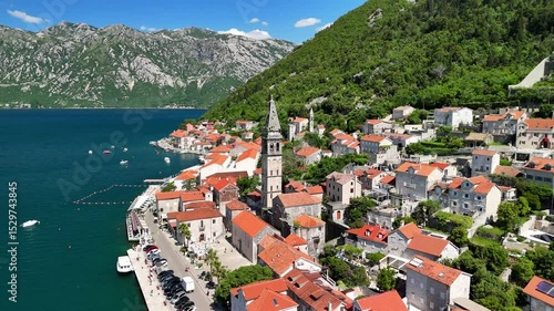 Aerial view of the historic town of Perast, located in the famous Bay of Kotor, on a bright and sunny  day with a blue sky.A drone flies over the picturesque resort town with a rich history.Montenegro