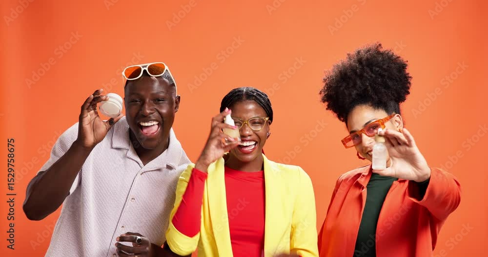 Skincare, product and promotion with friends in studio for beauty, cosmetologist and glow. Cosmetics, dermatology and hydration with people on orange background for aesthetic and facial treatment Skincare, product and promotion with friends in studio for beauty, cosmetologist and glow. Cosmetics, dermatology and hydration with people on orange background for aesthetic and facial treatment