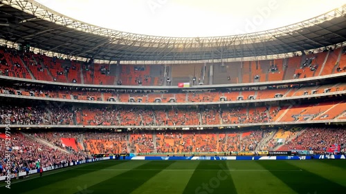 Enthusiastic crowd cheers inside vibrant football stadium during energetic match
