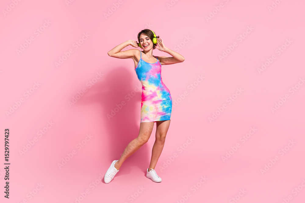 Young woman in colorful summer dress posing against pink background, exuding joy and confidence. Young woman in colorful summer dress posing against pink background, exuding joy and confidence.