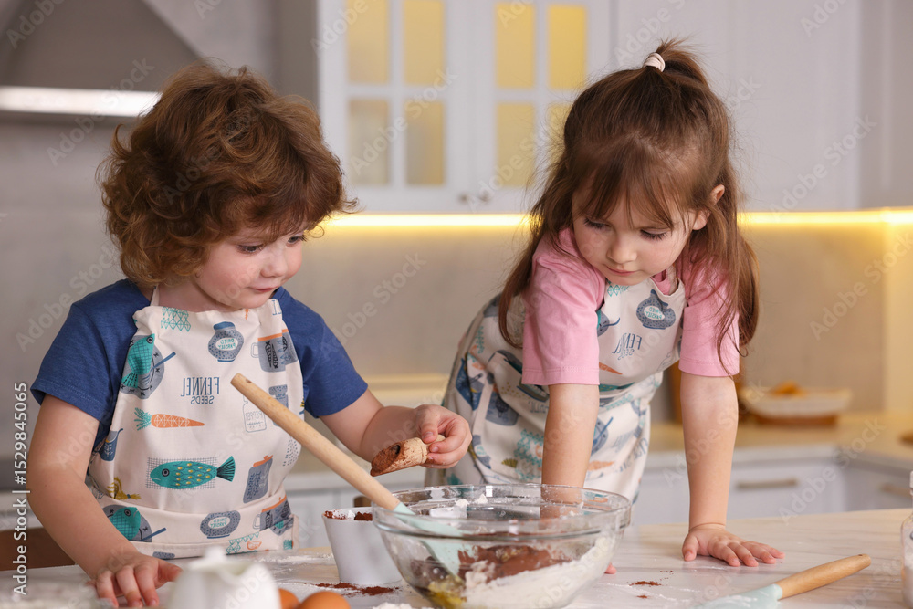 Fototapeta premium Cooking recipe. Cute children making dough for cookies at table in kitchen