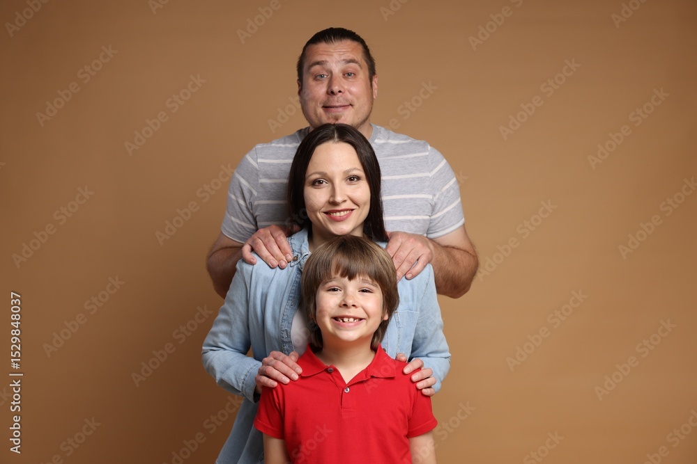 Fototapeta premium Portrait of happy family on brown background
