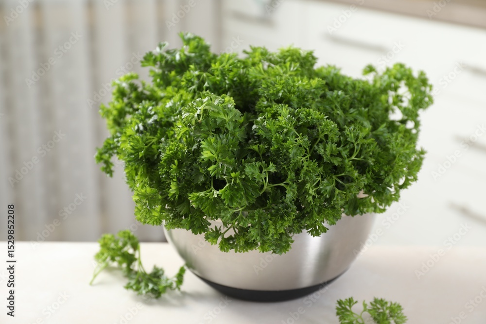 Fototapeta premium Fresh parsley in bowl on table indoors