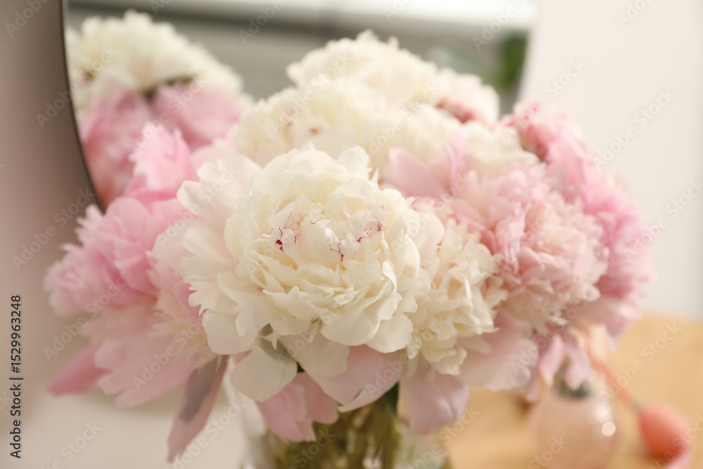 Beautiful peonies in vase on wooden vanity indoors, closeup Beautiful peonies in vase on wooden vanity indoors, closeup