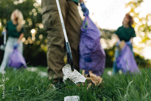 Εκτύπωση καμβά Group of people picking up trash in park with grabber tool