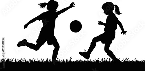 Silhouette of two girls playing soccer with a ball on a grassy field
