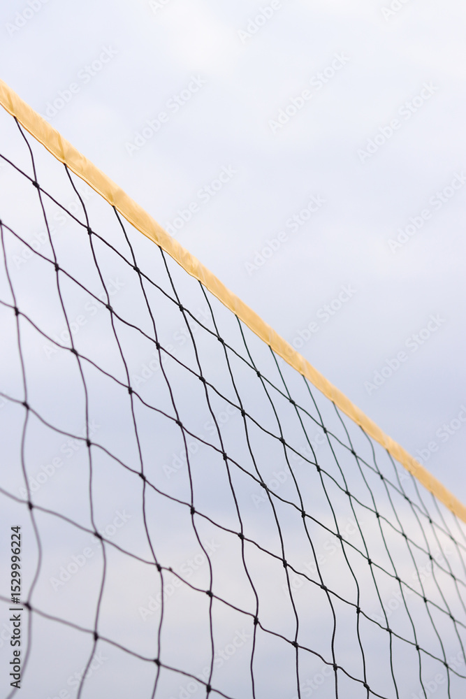Beach volleyball net close-up. Volleyball net fragment on the beach against the sky. Sport, beach volleyball. Active recreation concept. Background. Yellow net detail. Sports ground Beach volleyball net close-up. Volleyball net fragment on the beach against the sky. Sport, beach volleyball. Active recreation concept. Background. Yellow net detail. Sports ground