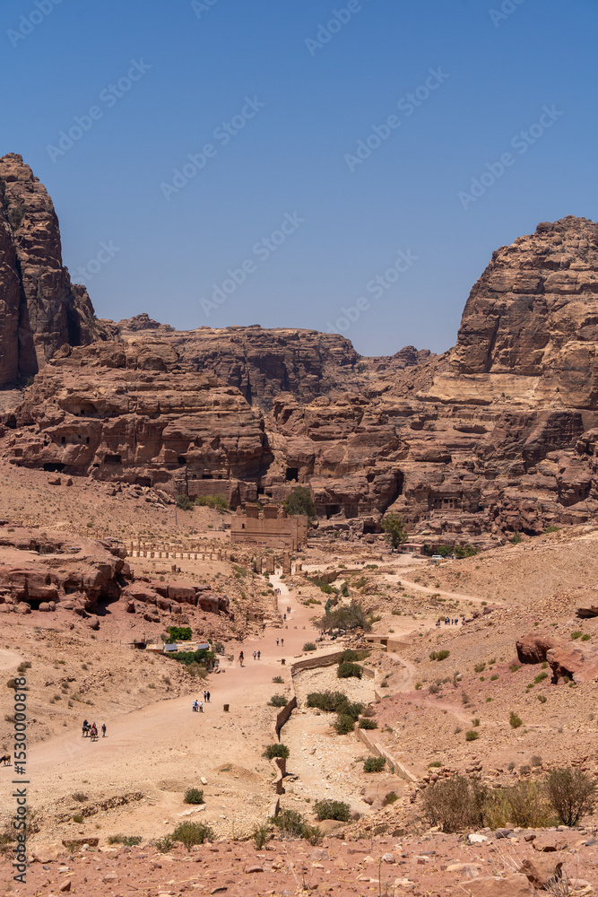 Fototapeta premium Ancient City Journey: A breathtaking perspective of the historic site, revealing the intricate rock formations and architectural wonders, under the vast, azure sky, evokes a sense of awe and wonder.